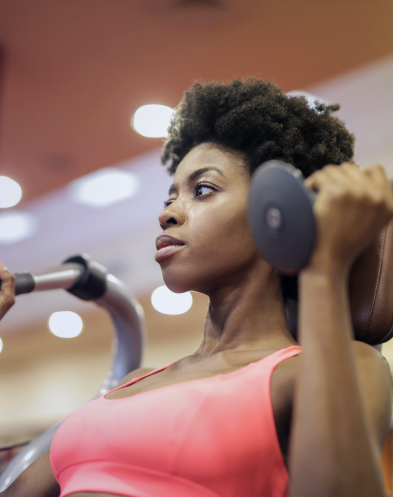 a girl exercises her arms with dumbbells