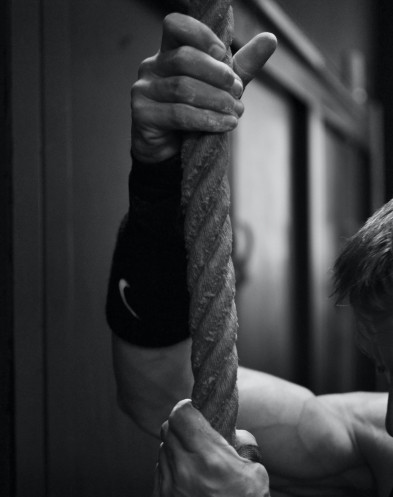 the man's hands hold the rope